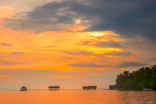 Indonesien. Raja Ampat-Archipel. Lange Brücken, ein Pier und mehrere Hütten. Farbenfroher Sonnenuntergangshimmel