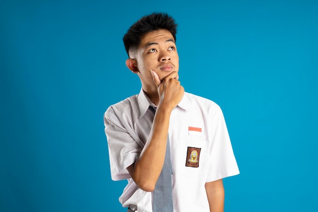 Indonesische Gymnasiasten posieren denkend und tragen typische grau-weiße Uniformen