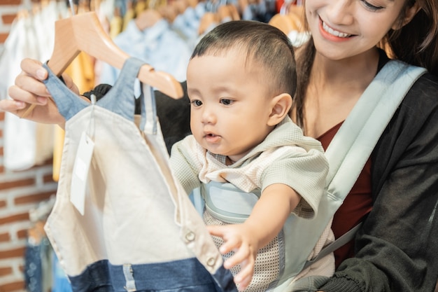 Indonesische Mutter kauft Kleidung für ihren Sohn in der Babyboutique