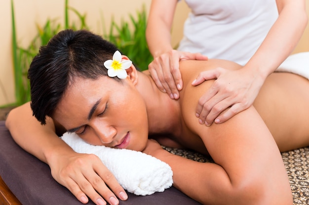 Indonesischer asiatischer Mann im Wellness-Schönheits-Spa mit Aromatherapie-Massage mit ätherischem Öl, das entspannt aussieht