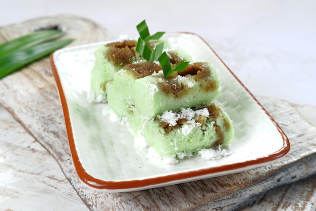 Indonesischer traditioneller Kuchen, Kue Putu Bambu, hergestellt aus Reismehl, Palmzucker, gerieben mit Kokosnuss.