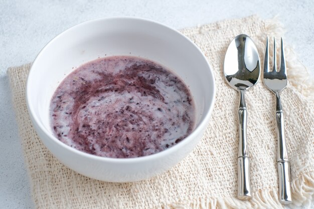 Indonesisches traditionelles Dessert, Bubur Ketan Hitam oder schwarzer Klebreisbrei mit Kokosmilchsauce