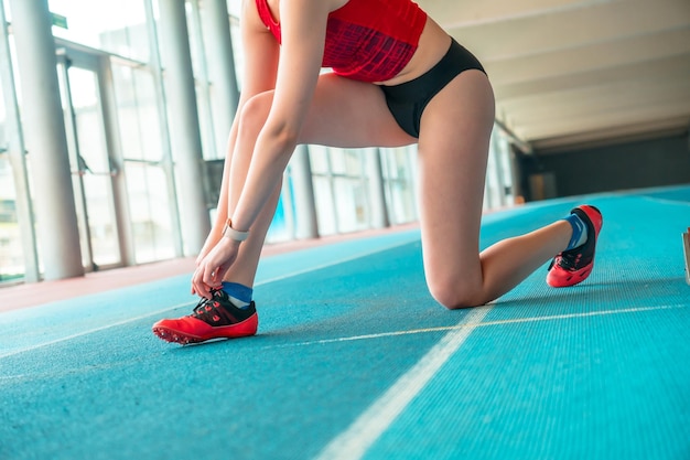 Indoor-Leichtathletik-Sprinterin, die Schuhe für das Training vorbereitet