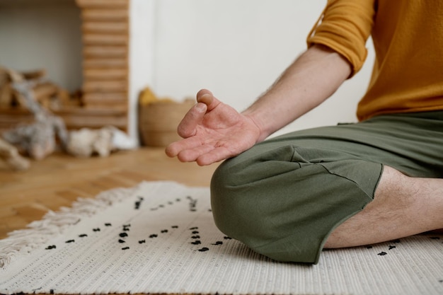Foto indoor-meditation für inneres gleichgewicht und ohne stress achtsamkeitspraxis konzept abgeschnitten mit nahaufnahme auf yogi männliche hand in gyana mudra