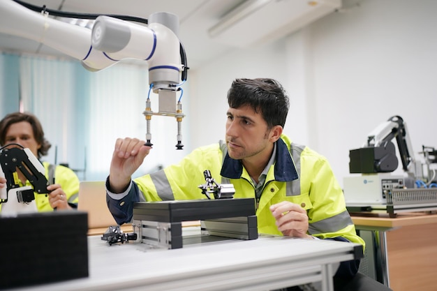 Industria 40 Joven ingeniero trabaja en un brazo robótico