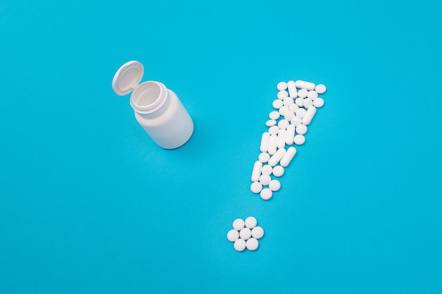 Industria farmacéutica y productos medicinales signo de exclamación blanco sobre mesa azul