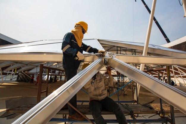 La industria química del trabajador masculino del petróleo y del gas con la cúpula del tanque de almacenamiento del techo superior del combustible de aluminio.