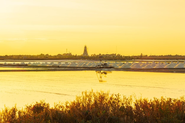 industria de la salpuesta de sol en un lago salado rosadoCultivo de sal al atardecer Naklua en la costa de Phetchaburi