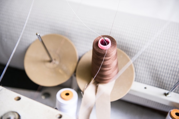 Foto industria textil. hilos en la máquina de coser, herramientas y accesorios en el taller de costura.