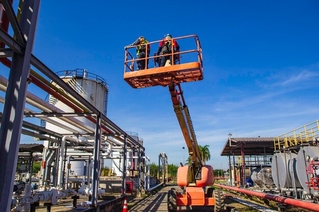 Industrie mit zwei Männern, die hoch in einer Hebebühne arbeiten