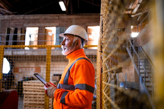 Industriearbeiter, der in der Produktionsfabrikhalle steht