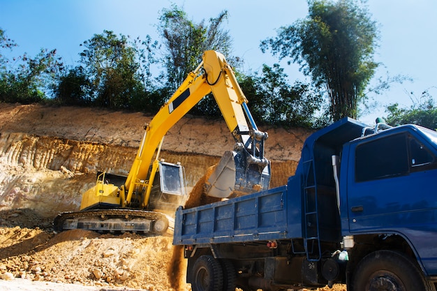 Industriebagger und LKW arbeiten auf der Baustelle, um das Land von Sand und Boden zu reinigen