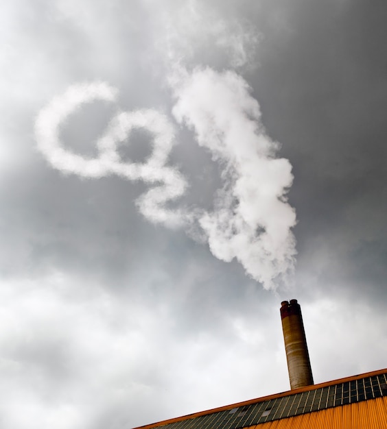 Industriekaminfabrik mit seinem weißen CO2-Rauch