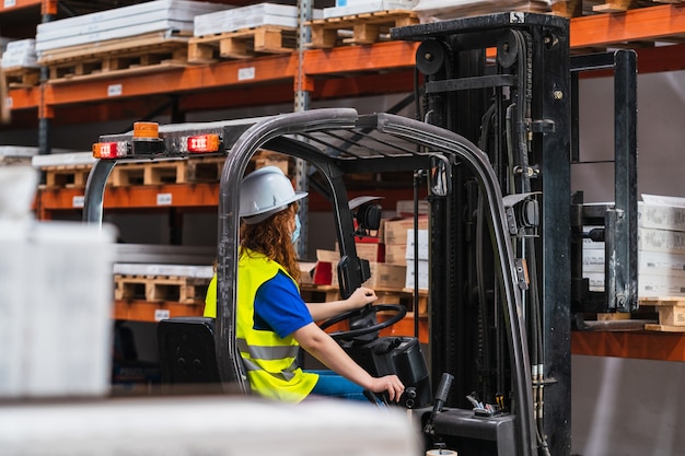 Industrielle Arbeiterin mit einem Lader in einem Lager