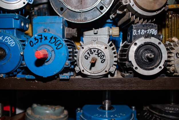 Industrielle Elektromotoren in der Garage auf dem Gestell. Elektrische Ausrüstung in Reparatur, Asynchronstromgeneratoren, Nahaufnahme