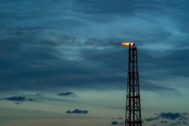 Industrielle Fackel zur Verbrennung von Erdölbegleitgas vor dem Hintergrund des Himmels