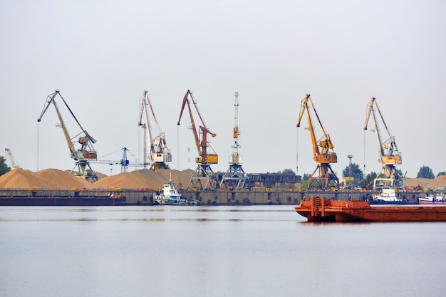 Industrielle Flusslandschaft mit Frachtterminal und Anlegestellen für Schlepper und Schüttgutkähne