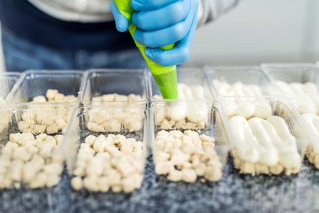 Industrielle Produktion von Lebensmitteln. Konditor macht köstliche Desserts auf Fabrik.