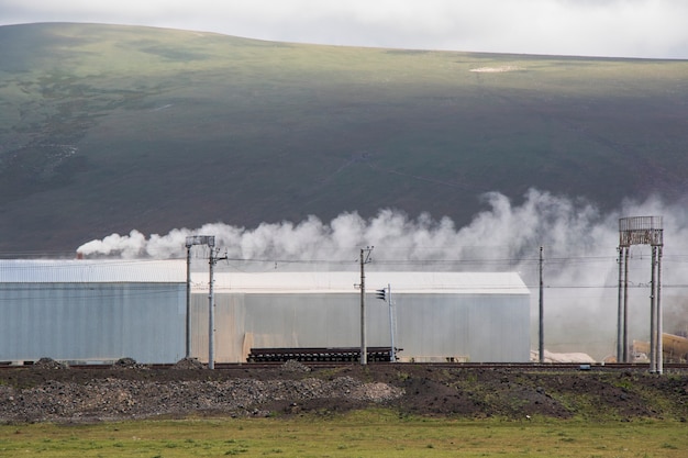 Industrielle Verschmutzung, Smog und Nebel, große Rauchrohre, giftige Luft. Wolken mit Verschmutzung und Berglandschaft in Tsalka, Georgia