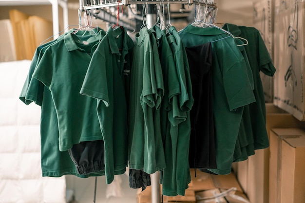 industrielle Wäsche im Hotel saubere Hemden von Mitarbeitern und Gästen sortiert nach dem Waschen hängen an Wäscheleinen Konzept der Sauberkeit und Gastfreundschaft