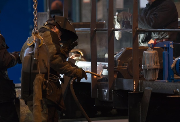 Foto industrielles konzept. ein mannschweißer, der in der fabrik arbeitet. mittlerer schuss