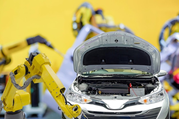 Industrieroboter arbeiten mit Automobil auf verschwommenem Hintergrund der intelligenten Autofabrik