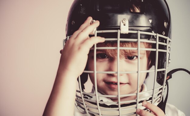 Infancia deportiva Futura estrella deportiva Educación y carrera deportiva Niño lindo usar casco de hockey de cerca Seguridad y protección Rejilla protectora en la cara Equipo deportivo Casco de hockey o rugby