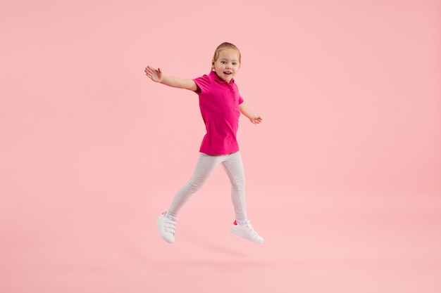 Infância e sonho com futuro grande e famoso Menina bonita isolada em fundo rosa coral