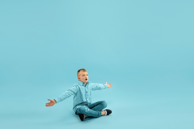 Infância e sonho com futuro grande e famoso. menino bonito isolado no fundo azul