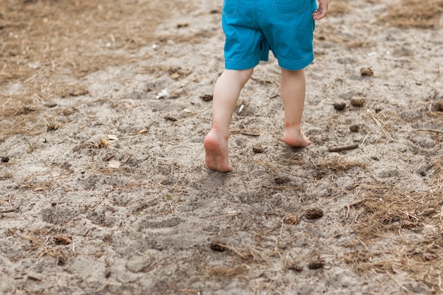 infancia feliz en la naturaleza. pies de niños descalzos en el suelo