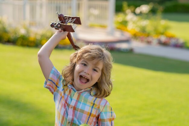 Infancia feliz Sueño de volar Niños pequeños con un avión de juguete en un campo al atardecer Éxito y concepto de líder infantil El niño sueña con convertirse en piloto