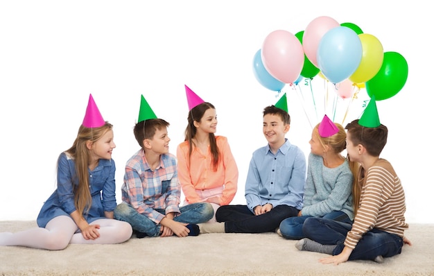 infância, feriados, amizade e conceito de pessoas - crianças sorridentes felizes em chapéus de festa no aniversário