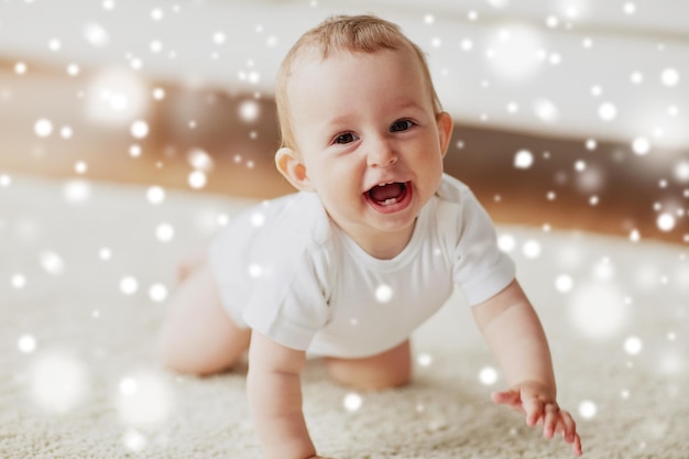 infancia infancia y gente concepto feliz sonriente pequeño bebé niño o niña arrastrándose por el suelo en casa sobre la nieve