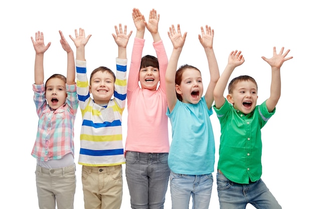 infancia, moda, gesto y concepto de la gente - felices amigos sonrientes levantando puños y celebrando la victoria