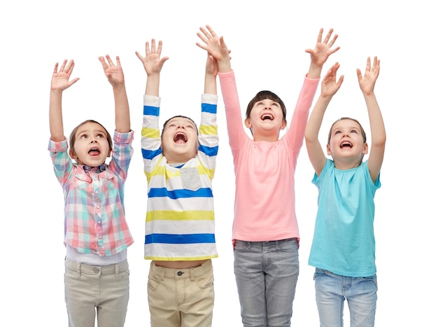 infancia, moda, gesto y concepto de la gente - felices amigos sonrientes levantando puños y celebrando la victoria