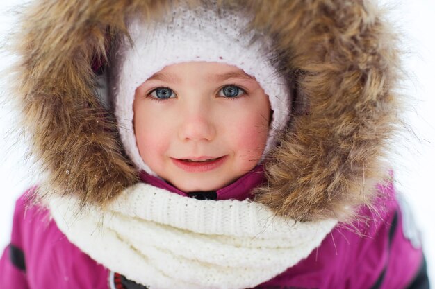 infância, moda, temporada e conceito de pessoas - rosto de criança feliz ou menina em roupas de inverno