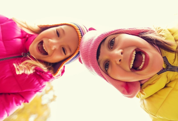 Infancia, ocio, amistad y concepto de personas - caras felices de chicas riendo al aire libre