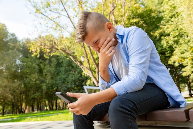 Infancia, realidad aumentada, tecnología y concepto de personas: niño con teléfono inteligente jugando al aire libre en verano