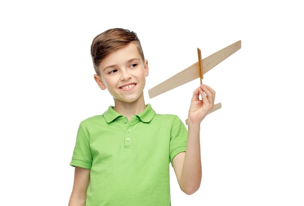 infancia, sueño y concepto de la gente - niño sonriente feliz en camiseta polo verde con avión de juguete