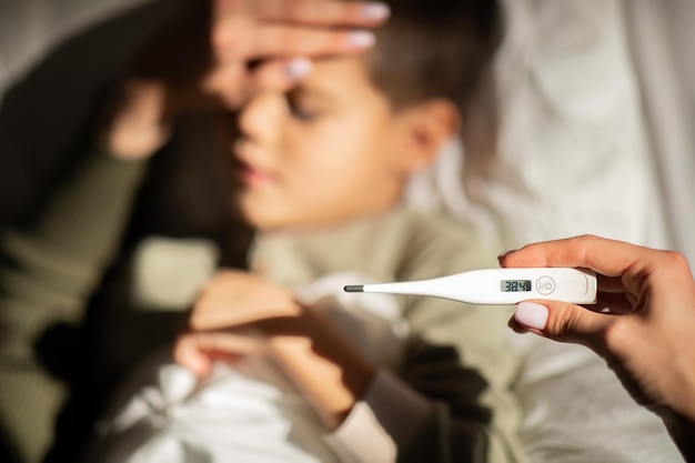 Infeliz criança caucasiana sofre de febre mãe mede termômetro de show de temperatura