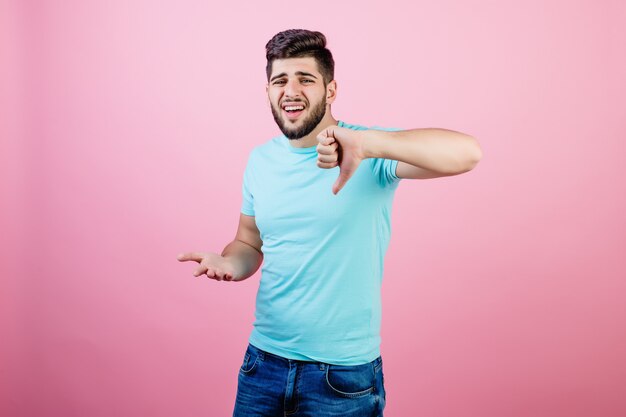 Foto infeliz hombre del medio oriente mostrando los pulgares hacia abajo