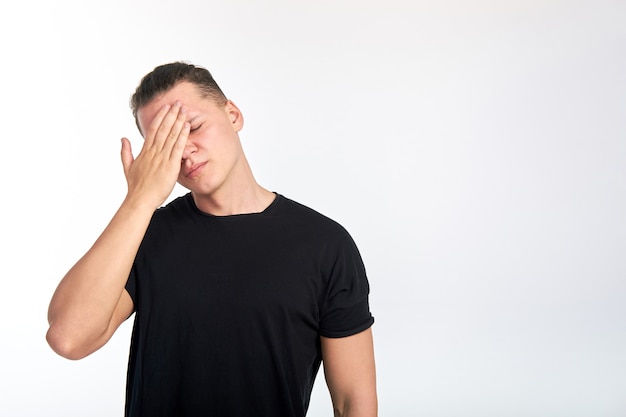 Infeliz joven con los ojos cerrados tocando la cabeza