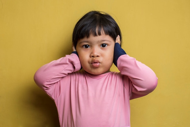 Infeliz niña asiática cerrar sus oídos