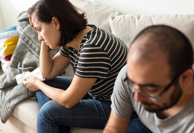 Foto infeliz pareja discutiendo en el sofá