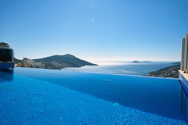 Foto infinity-pool mit meer- und meerblick auf blauem himmelshintergrund sommerurlaub