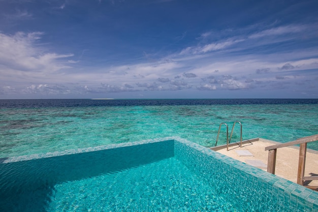 Infinity-Pool mit Stufen in die atemberaubende blaue Lagune. Meereshorizont, sonniger Himmel. Inspirieren Sie Luxusreisen