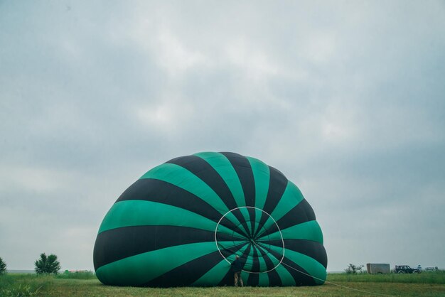 Inflar desempaquetar y volar sandía en globo de aire caliente Quemador dirigiendo la llama hacia el sobre Despegar el vuelo del avión en el cielo azul de la mañana Comience a quemar aire caliente para inflar el fuego de gas al globo de aire