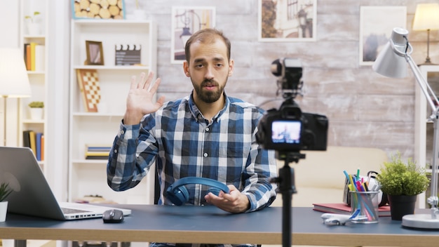 Influencer famoso grabando una reseña de unos auriculares geniales. Creador de contenido creativo.