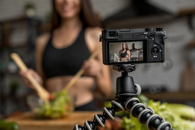 Foto influencer girl en línea en las redes sociales en vivo vaporizando el concepto de comida saludable