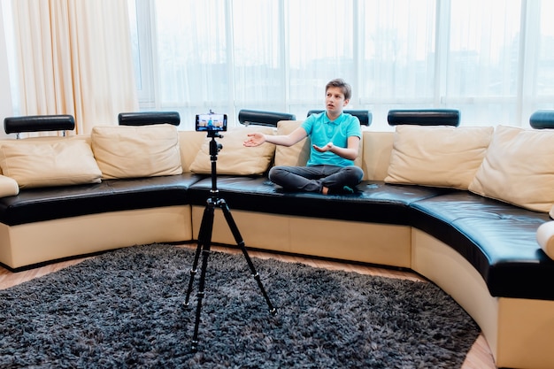 Influencer oder youtuber teenager, der ein video mit smartphone zu hause aufzeichnet